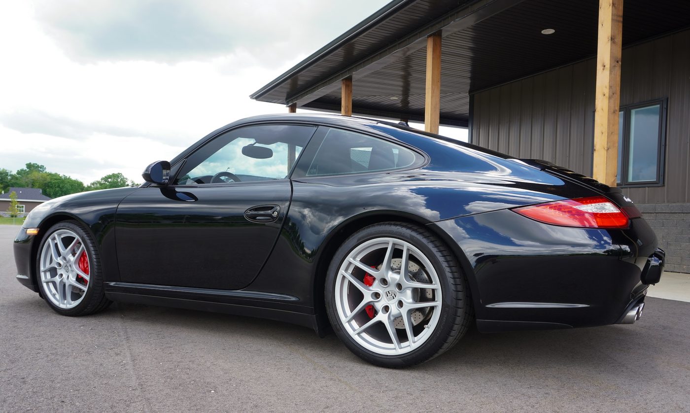 2010 Porsche 911 Carrera 4S, black, from behind under the showroom porch