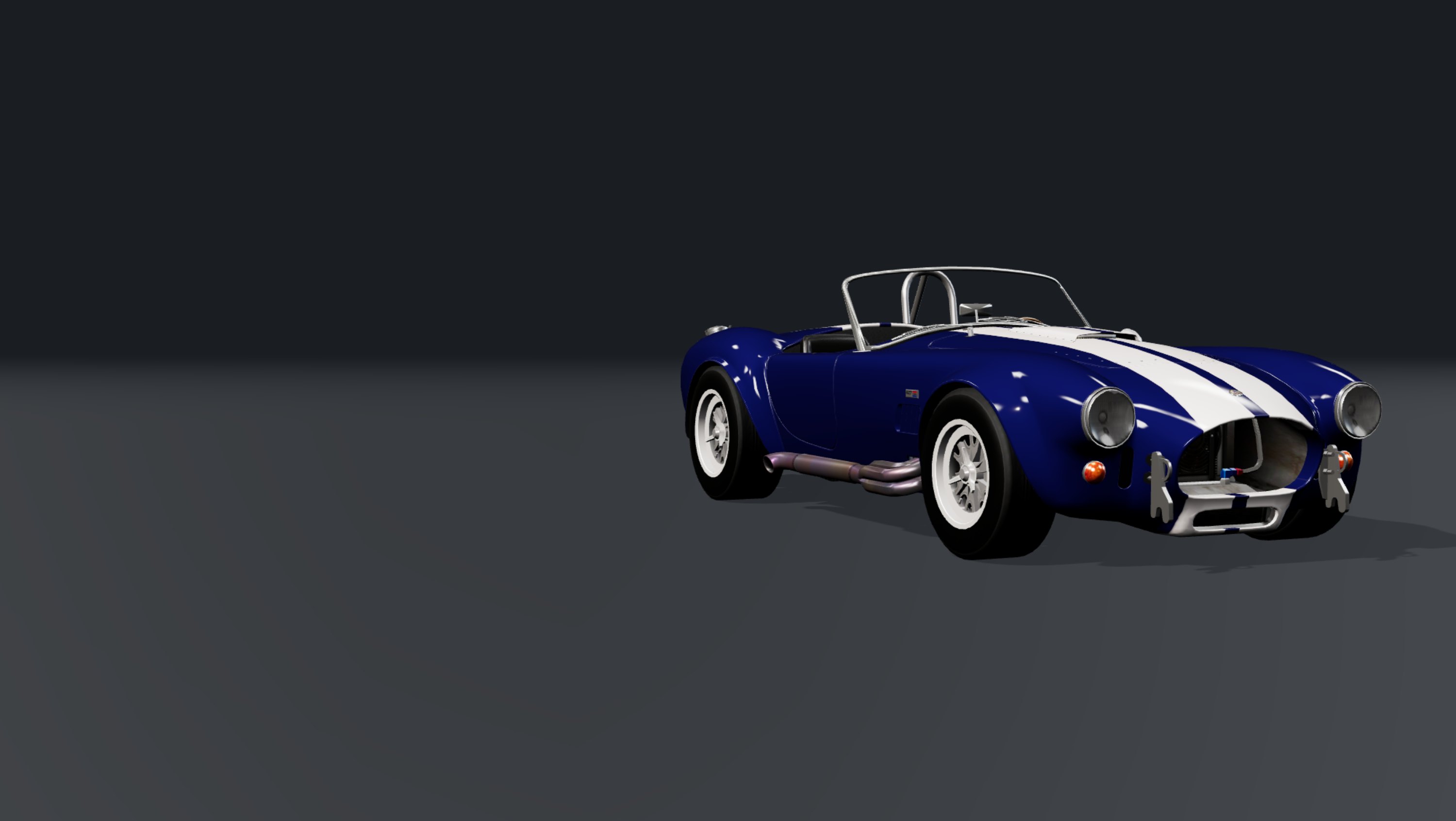 A Cobra roadster standing on a lit workshop floor, three-quarter view from the front