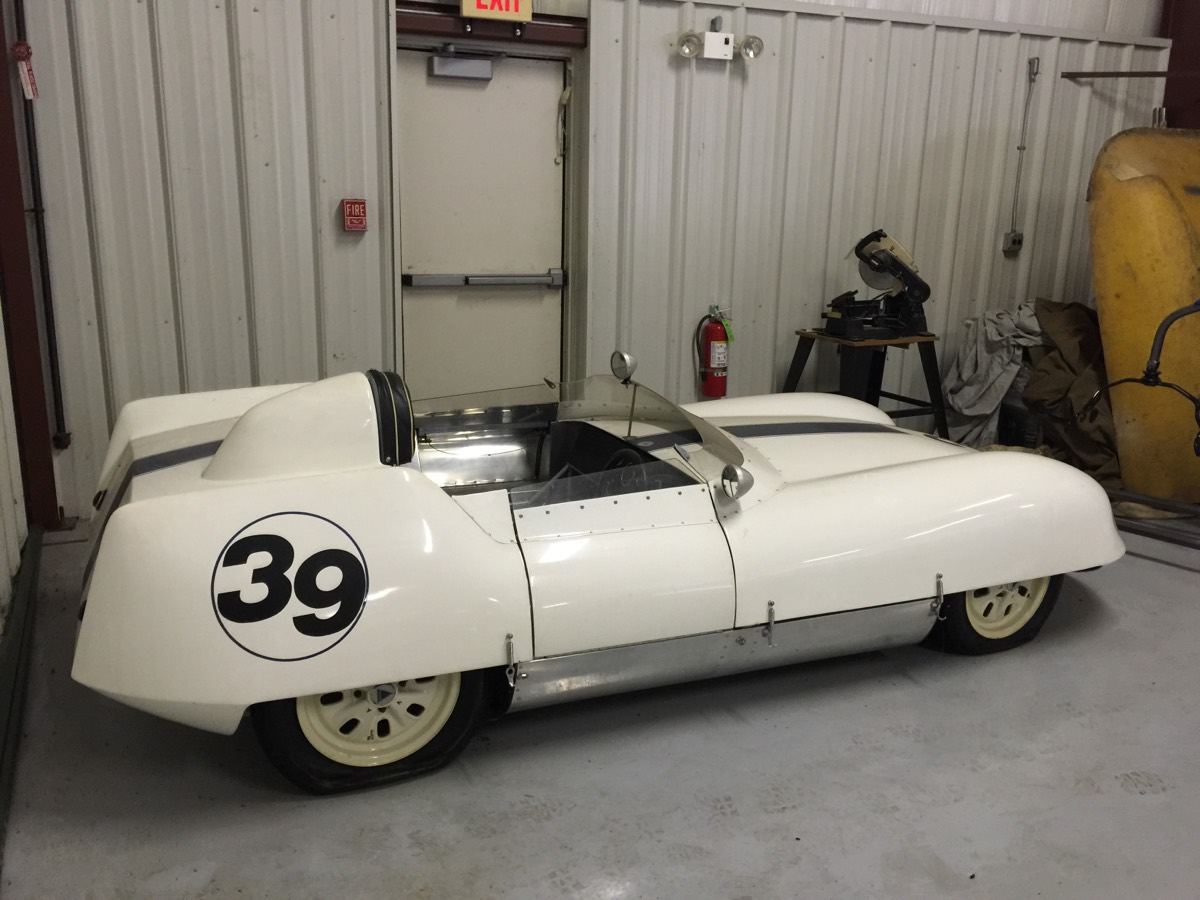 White open race car with the number 39, in a workshop
