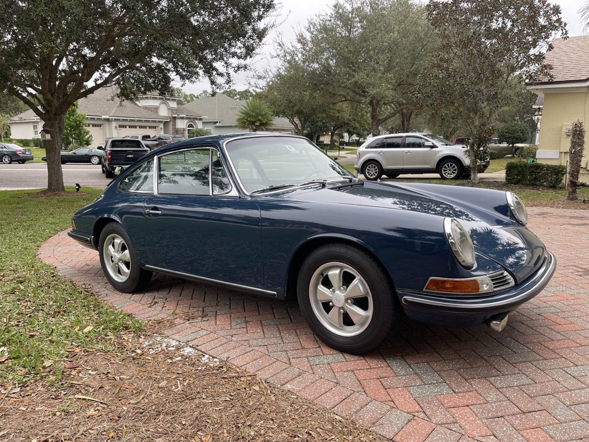 Slate blue 1960s coupe on a brick driveway